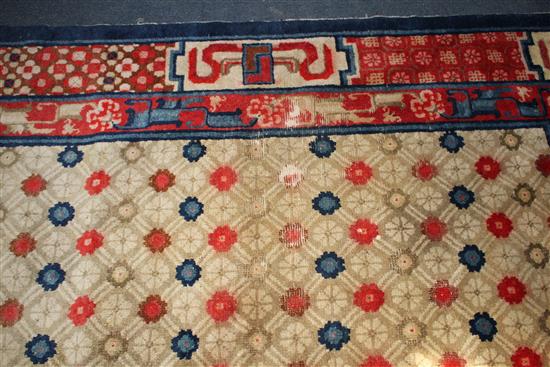 A small Chinese Suiyvan carpet, the fawn ground field woven with a lattice pattern, each cross centred by flowerheads, within a border